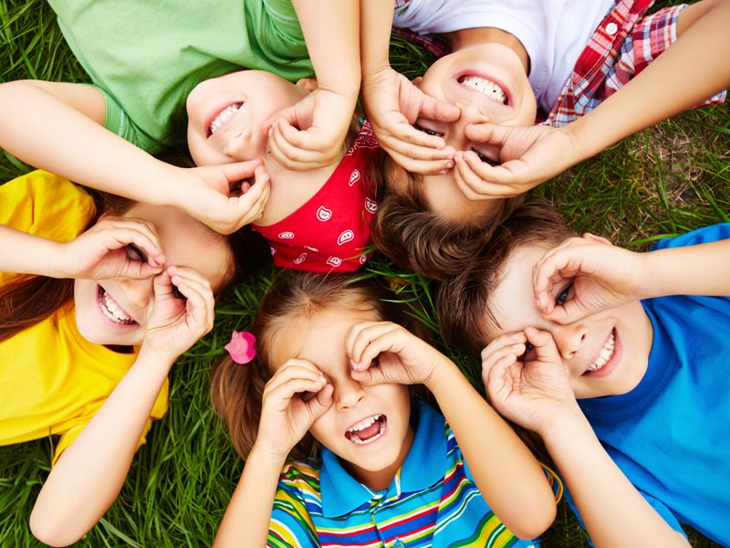 Group of cute children lying on grass